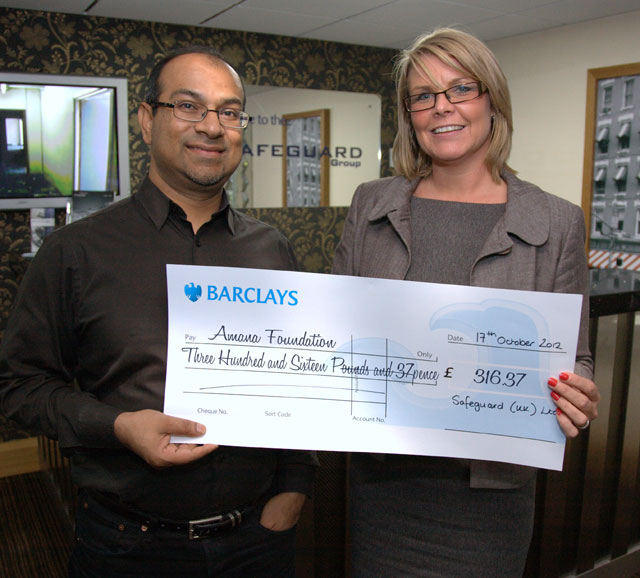 Muz Khan is presented with a queque by Kristina Atkins of Safeguard Group